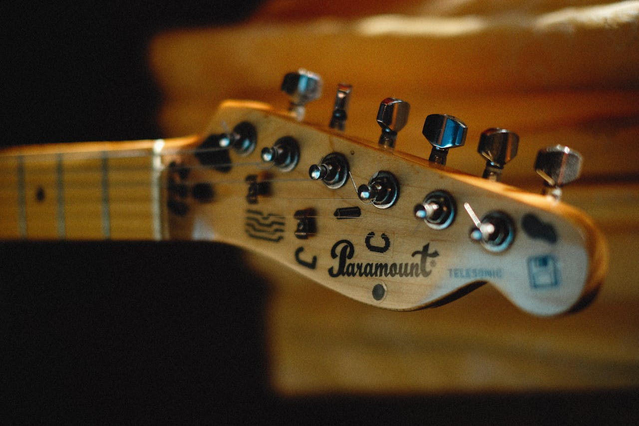 services-02 Detailed view of a Paramount electric guitar headstock with tuning pegs.