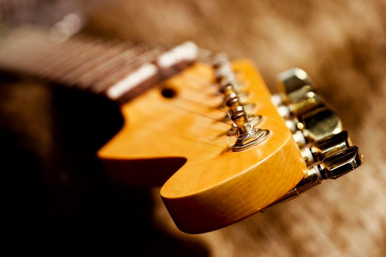 Detailed close-up of an electric guitars headstock showcasing its strings and tuning pegs.